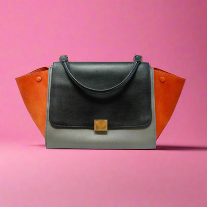 Black handbag with orange accents on a white background