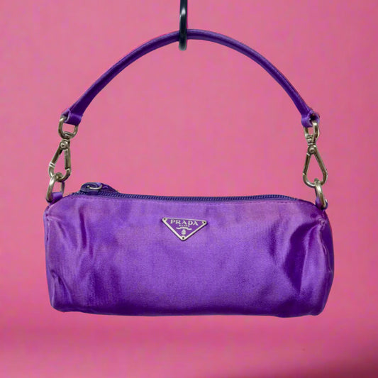 Purple handbag with Prada logo on a pink background