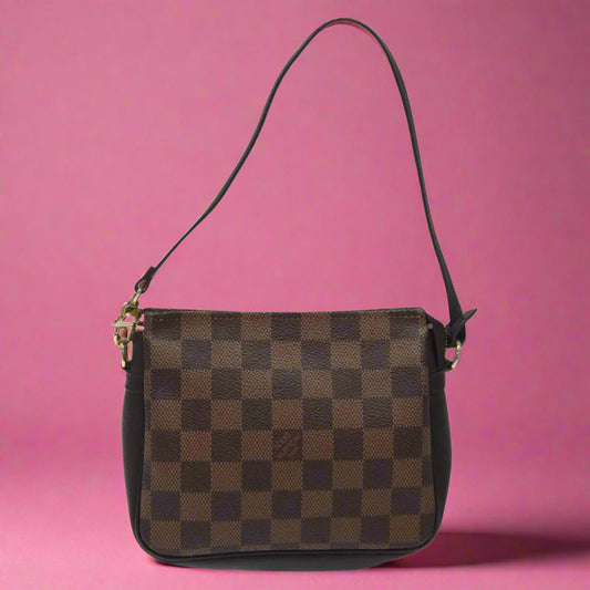 Brown checkered handbag with a visible brand logo on a white background